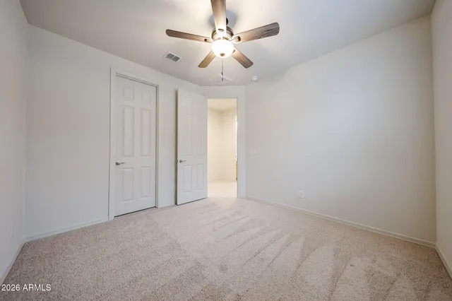 en empty room with fan and a ceiling fan
