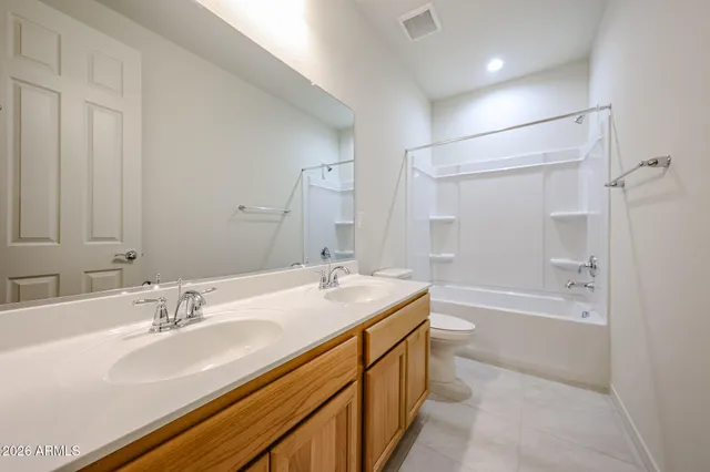a bathroom with a sink double vanity granite tub shower and a mirror