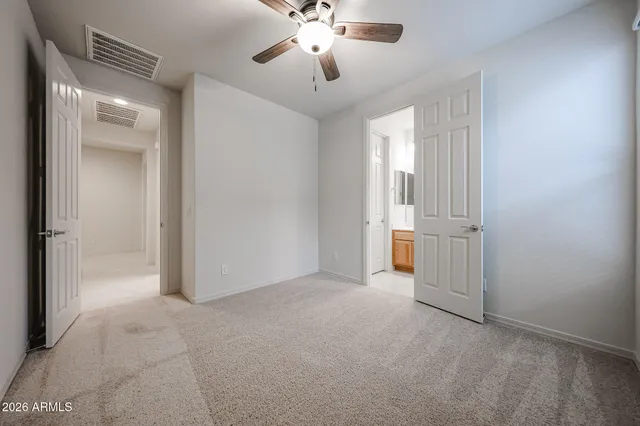 a view of a room with a ceiling fan and a bathroom