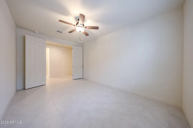a view of an empty room with a chandelier fan