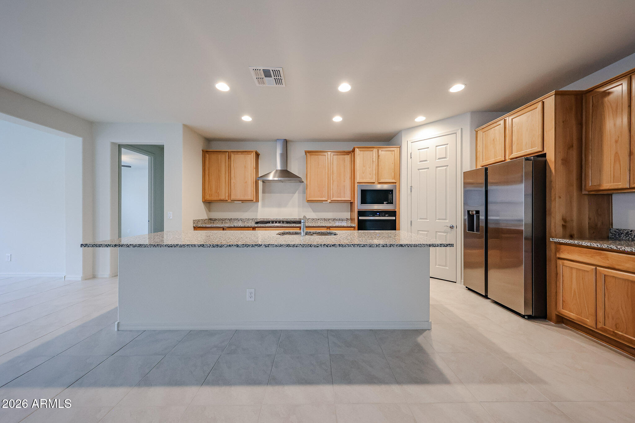 7078 West Plum Road Peoria, AZ 85383 - Photo 2 of 23 a large kitchen with kitchen island a large counter top stainless steel appliances and cabinets