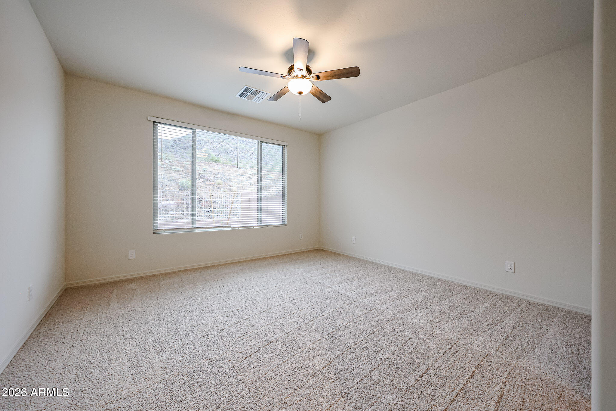 7078 West Plum Road Peoria, AZ 85383 - Photo 9 of 23 an empty room with chandelier fan and windows