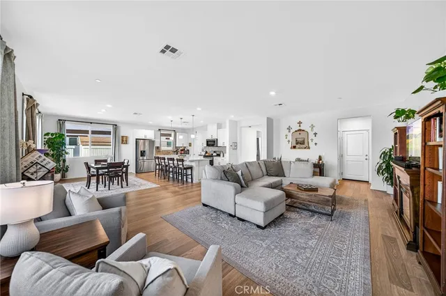a living room with furniture a wooden floor and a flat screen tv