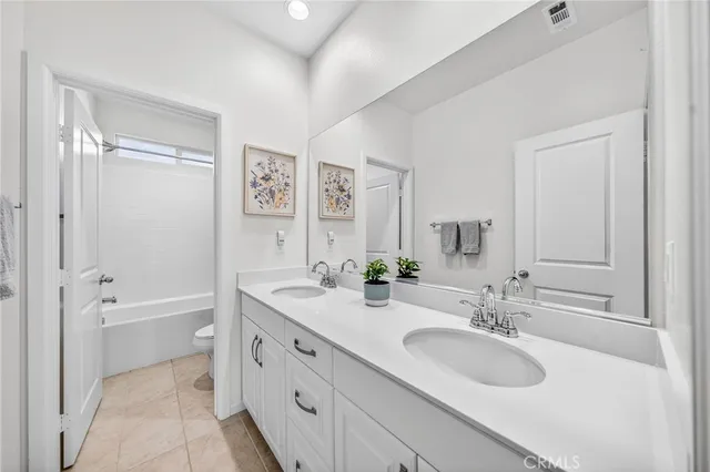 a bathroom with a granite countertop sink a mirror a bathtub and shower
