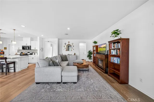 a living room with furniture kitchen view and a flat screen tv