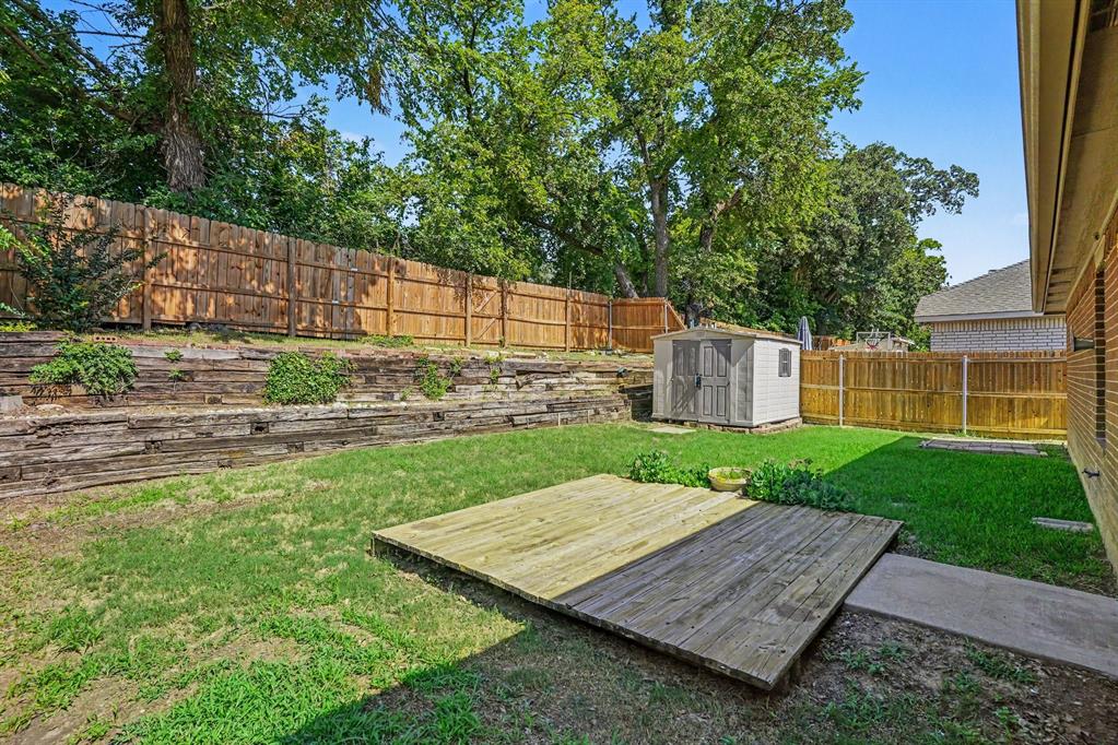 2541 Rivers Edge Drive Fort Worth, TX 76118 - Photo 28 of 31 a view of a backyard with a wooden fence