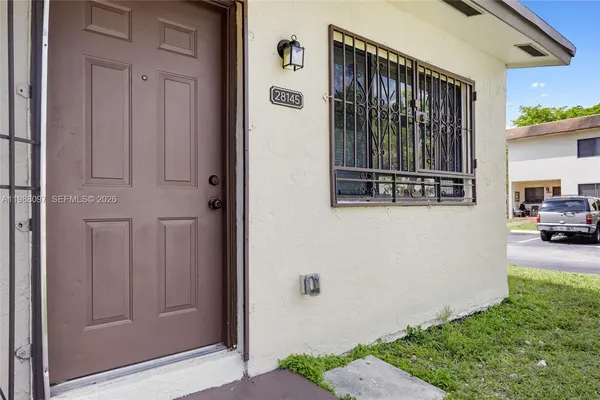 a view of a house with a door and a car park side of it
