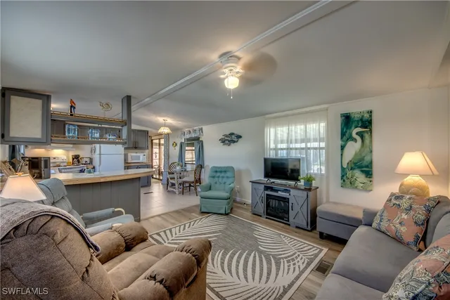 a kitchen with stainless steel appliances granite countertop a stove a refrigerator a sink dishwasher a dining table and chairs with wooden floor