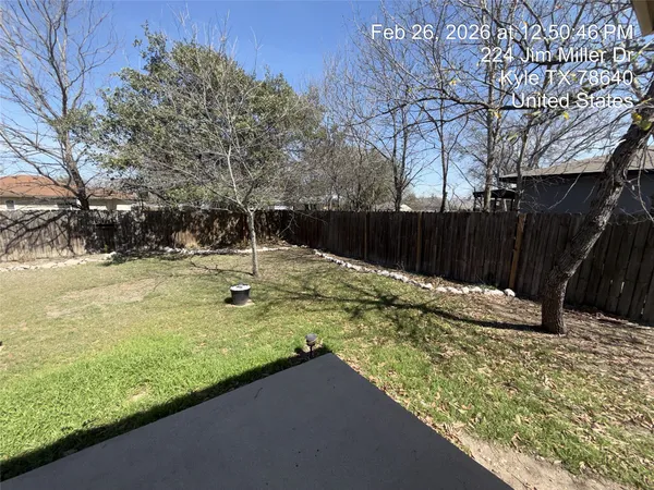 a view of a yard with wooden fence