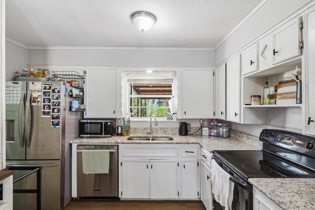 700 Amy Street Canton, TX 75103 - Photo 25 of 35 a kitchen with white cabinets sink and stainless steel appliances
