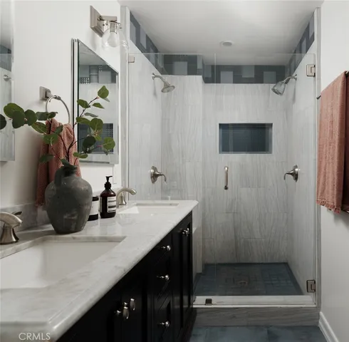 a bathroom with double vanity and a shower