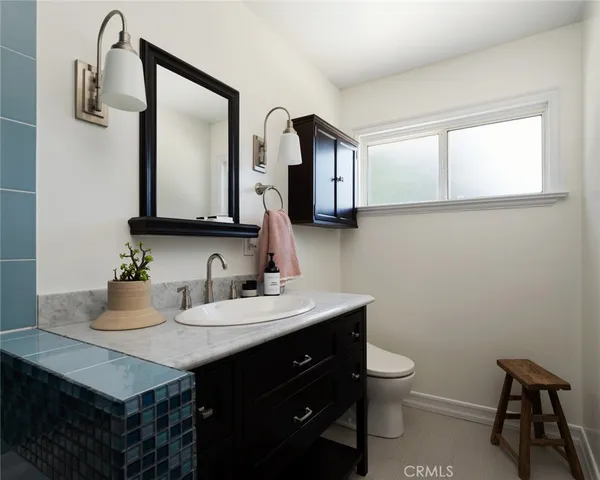 a bathroom with a toilet a sink a mirror and vanity