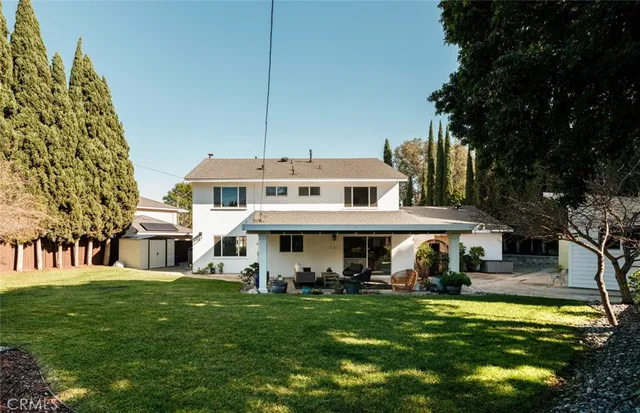 a view of a white house with a yard table and chairs
