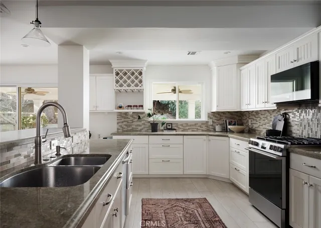 a kitchen with stainless steel appliances granite countertop a sink and a stove