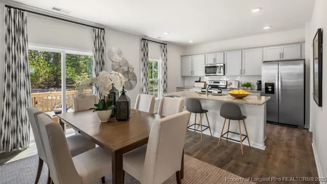 a kitchen with a table chairs and refrigerator