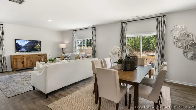 a living room with furniture a flat screen tv and a large window