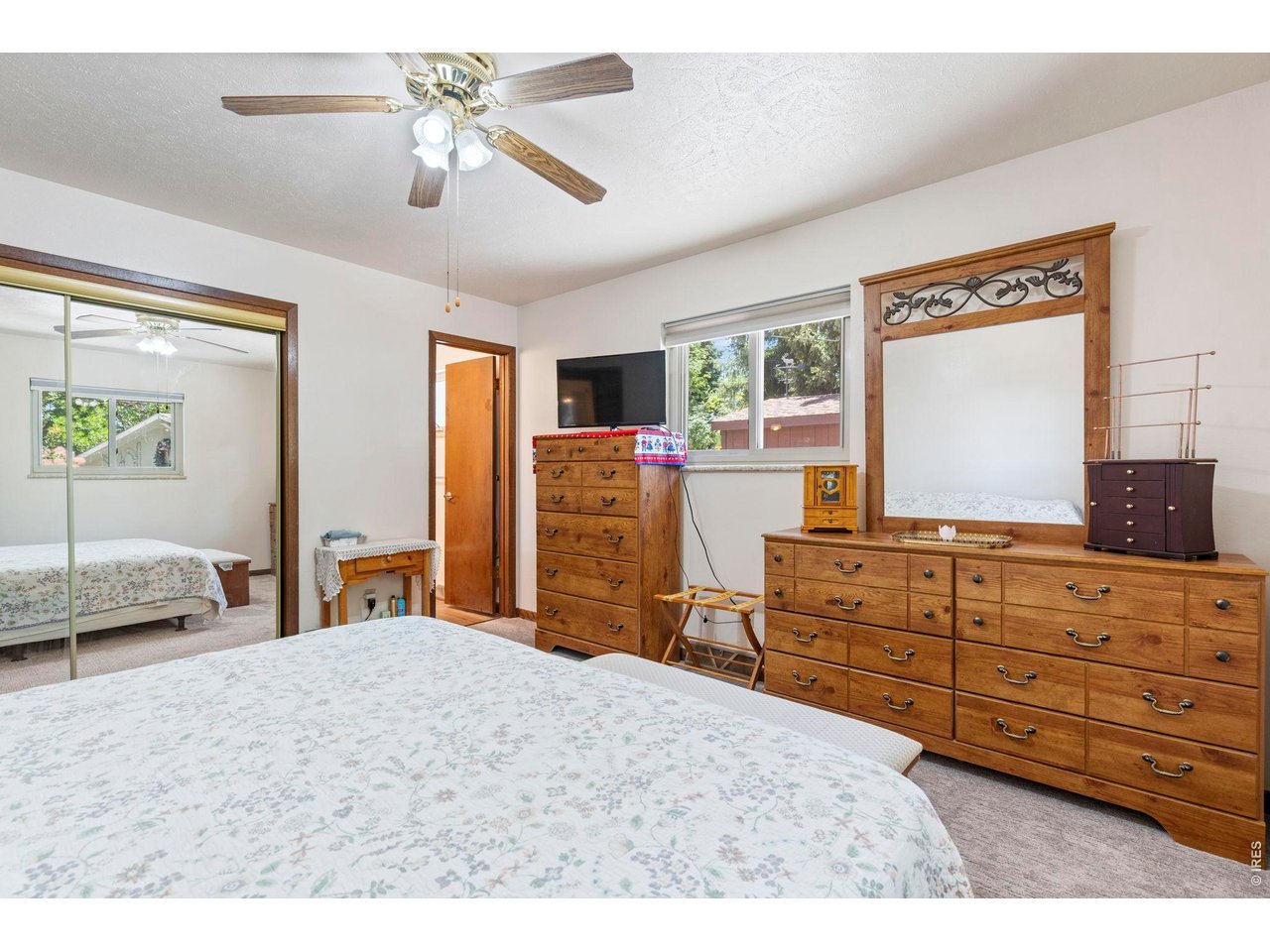 300 Ranch Acres Drive Loveland, CO 80538 - Photo 17 of 38 a bedroom with a large bed and a flat tv screen on dresser