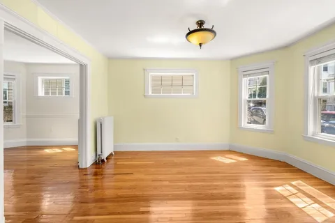 a view of a room with wooden floor and window