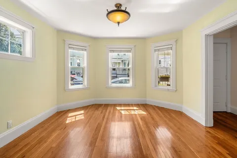 a view of a room with wooden floor and window