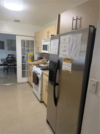 a kitchen with cabinets and refrigerator