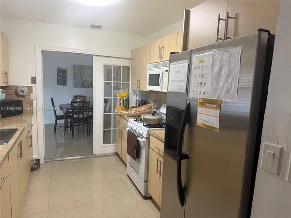 a kitchen with stainless steel appliances granite countertop a refrigerator and a stove
