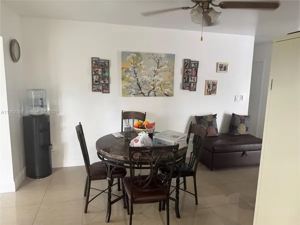 a view of a dining room with furniture and a chandelier fan