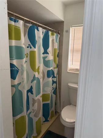 a white toilet sitting next to a bathroom sink and vanity