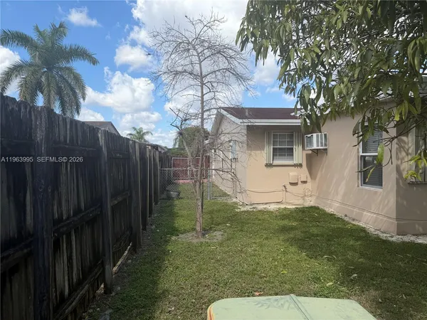 a backyard of a house with table and chairs