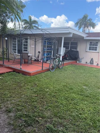 a view of a backyard with table and chairs under an umbrella