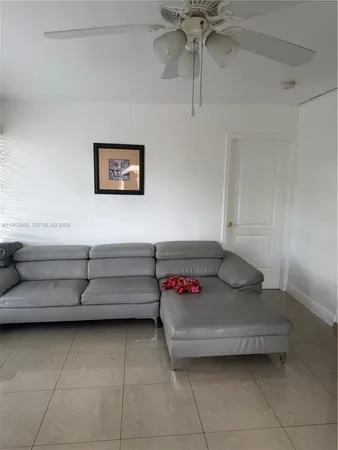a living room with furniture and a ceiling fan
