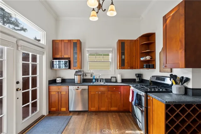 a kitchen with stainless steel appliances a sink cabinets and wooden floor
