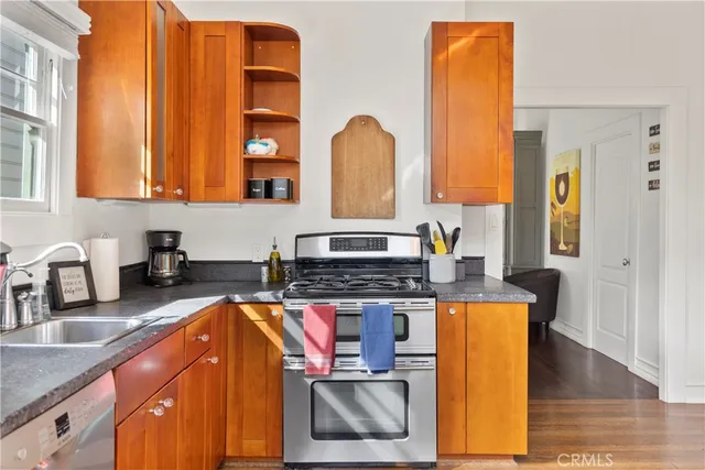 a kitchen with stainless steel appliances granite countertop a stove a sink and a microwave