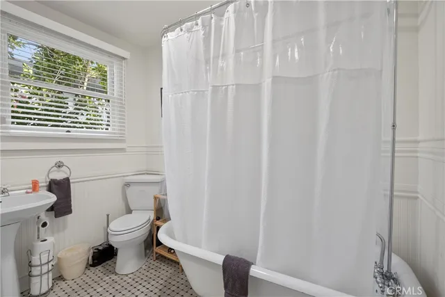 a white toilet sitting next to a shower curtain