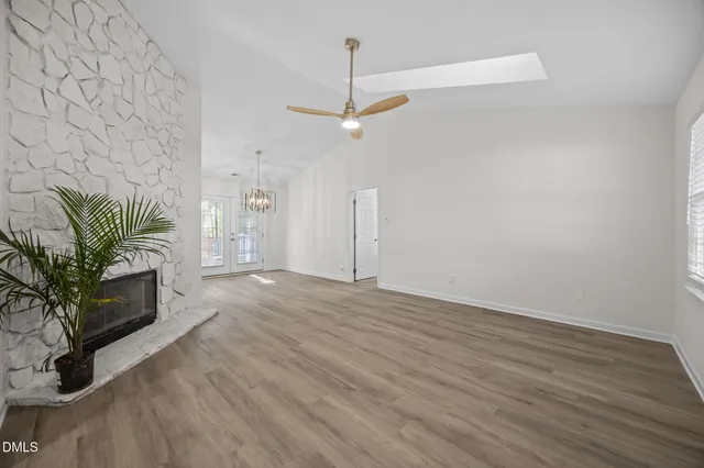 an empty room with a fireplace and wooden floor