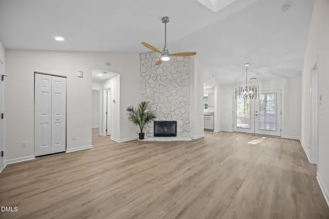 a view of a livingroom with wooden floor a ceiling fan and a window