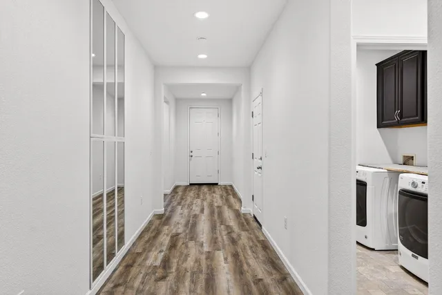 a view of a hallway with wooden floor and staircase