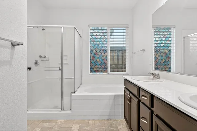 a bathroom with a granite countertop sink and a bathtub