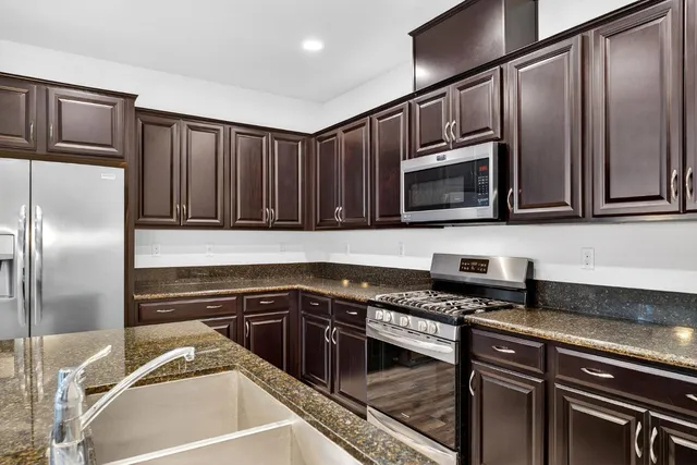 a kitchen with granite countertop stainless steel appliances and wooden cabinets