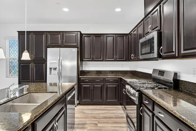 a kitchen with granite countertop stainless steel appliances and wooden cabinets