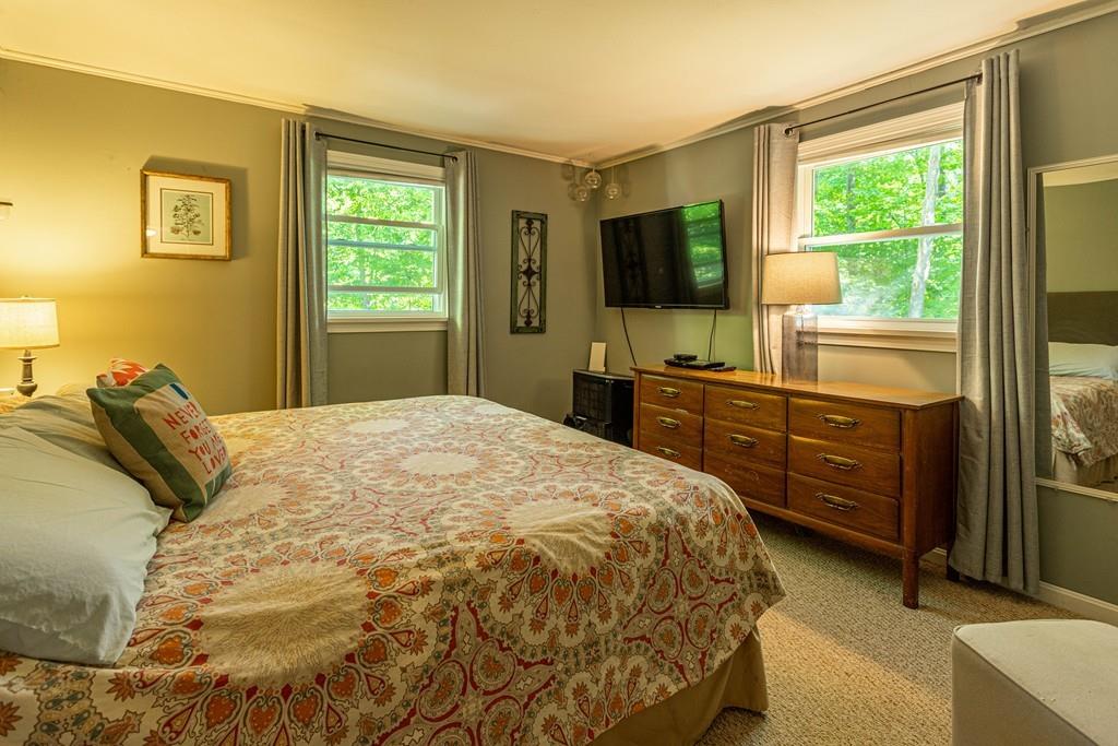 9 Holden Road Shirley, MA 01464 - Photo 22 of 42 a bedroom with a bed and a flat tv screen on dresser