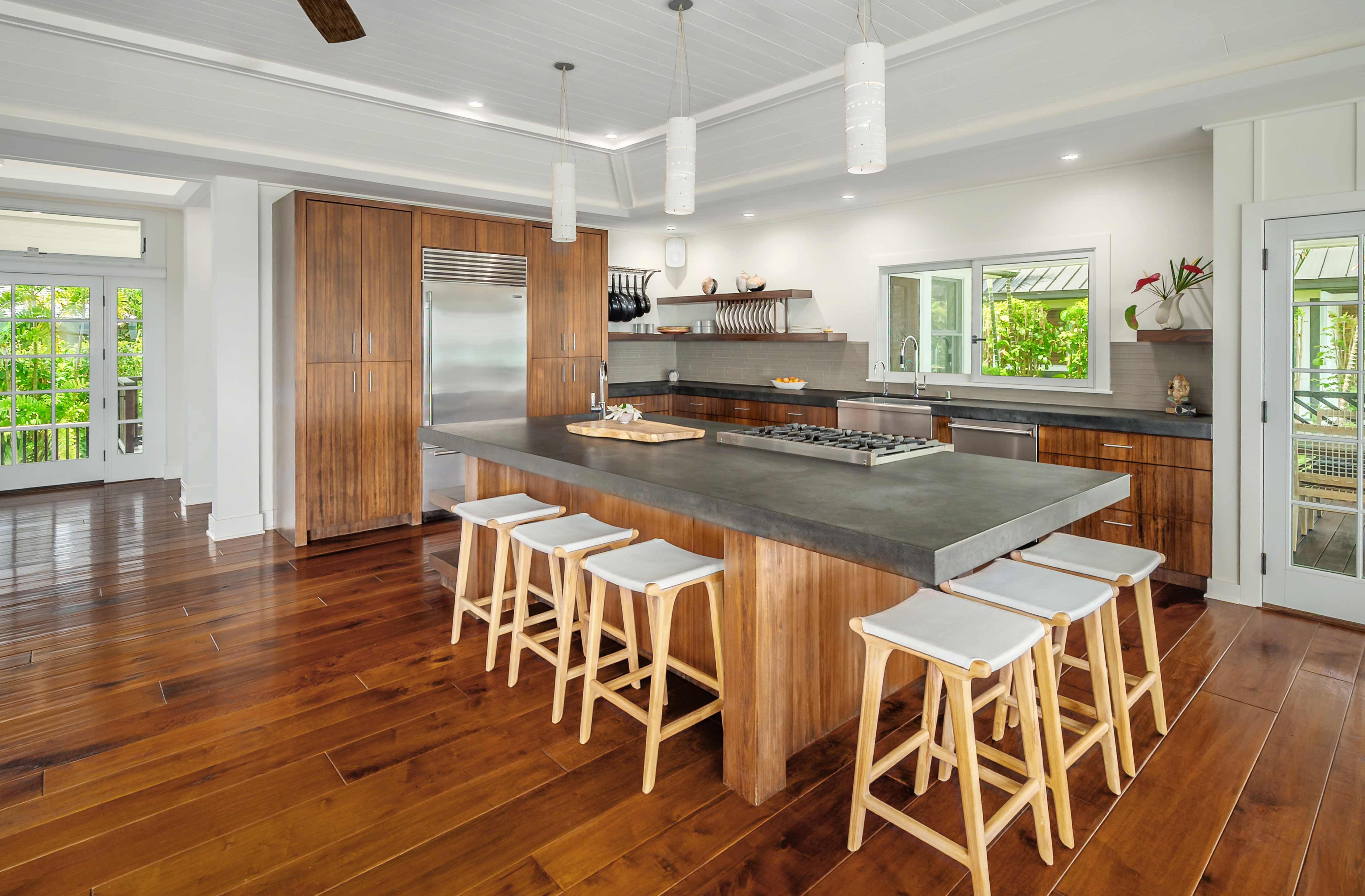 7336 Alealea Road Hanalei, HI 96714 - Photo 9 of 30 a kitchen with stainless steel appliances granite countertop a stove top oven a dining table and chairs with wooden floor