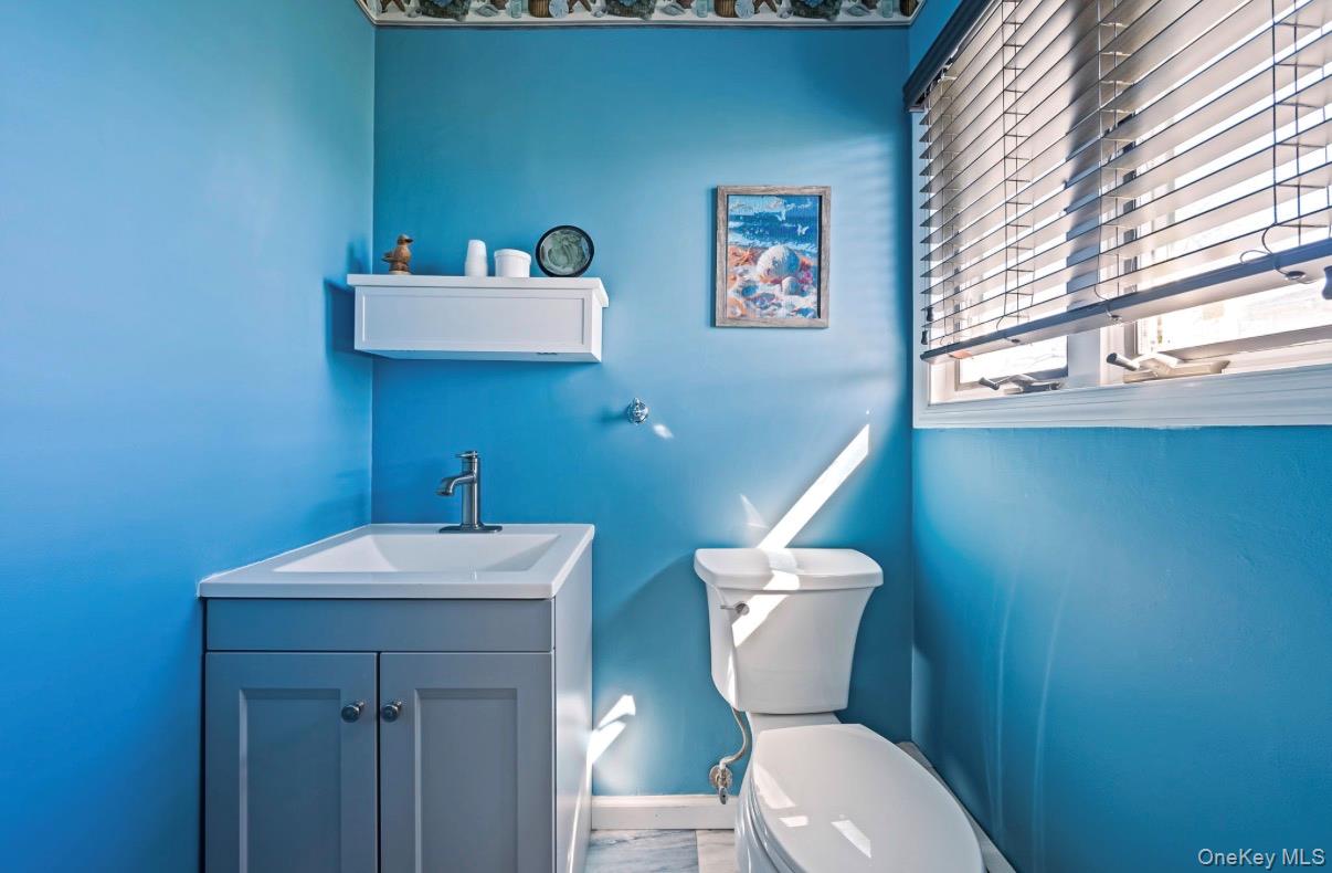 8 Leeward Lane Commack, NY 11725 - Photo 12 of 17 a bathroom with a toilet a sink and mirror