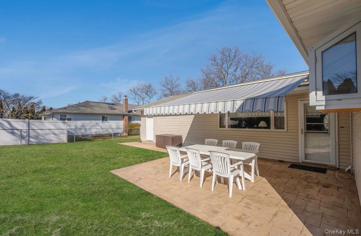 8 Leeward Lane Commack, NY 11725 - Photo 16 of 17 a view of a patio with table and chairs a barbeque and wooden fence