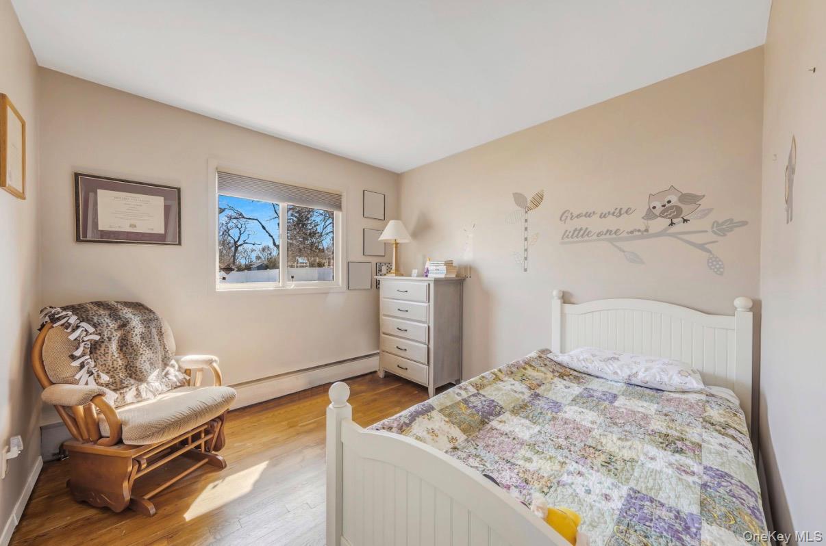 8 Leeward Lane Commack, NY 11725 - Photo 10 of 17 a bedroom with a bed and wooden floor