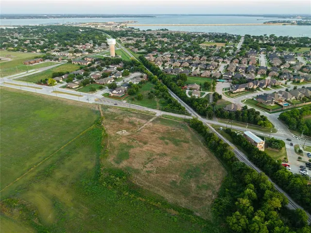 an aerial view of residential houses with outdoor space and trees