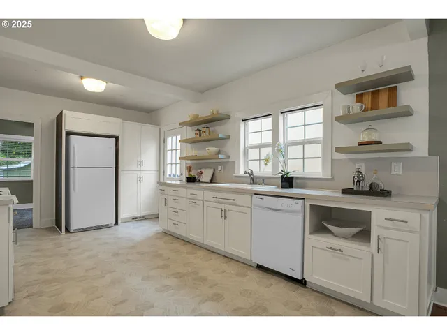 a kitchen with granite countertop white cabinets and white appliances
