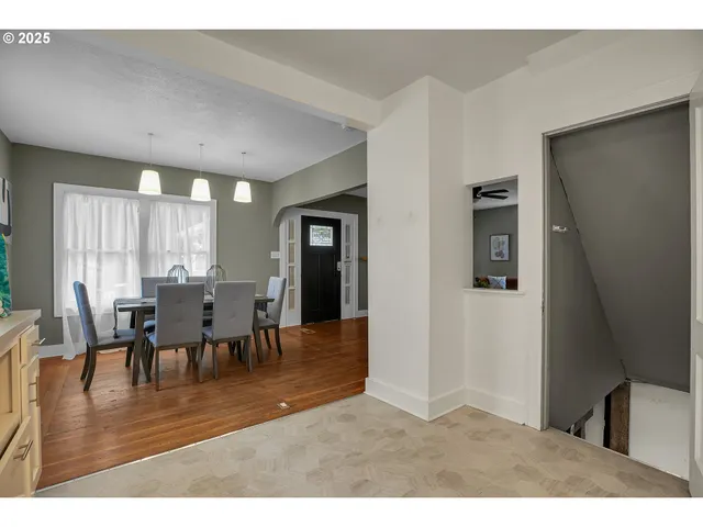 a view of dining room and livingroom with furniture wooden floor a rug a fireplace and a painting