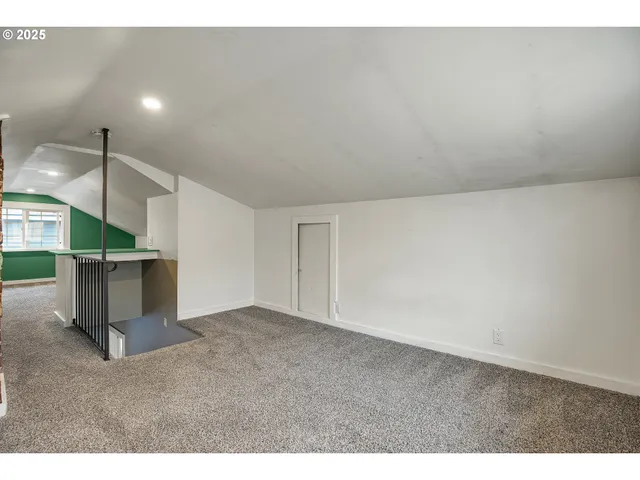 a view of an empty room with a window and a ceiling fan