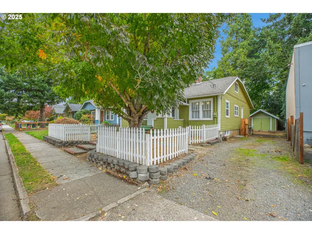 a view of a house with a yard and fence