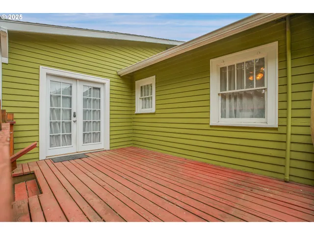 a backyard of a house with lawn chairs and a large window